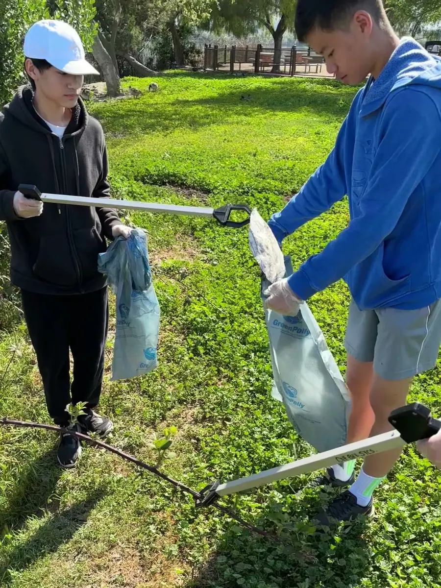 Two volunteers bagging litter collected along the creek