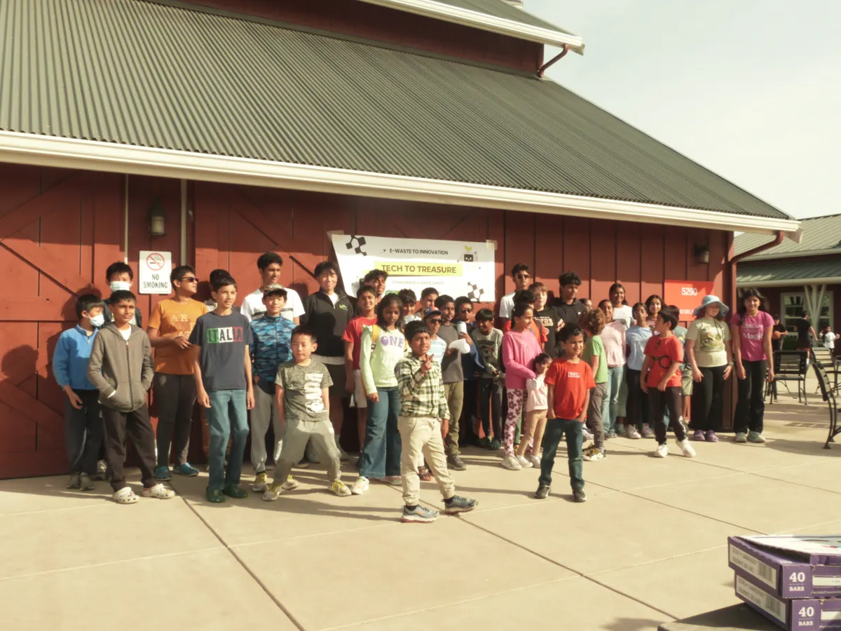 Workshop participants gathered in front of the red barn under the Tech to Treasure banner