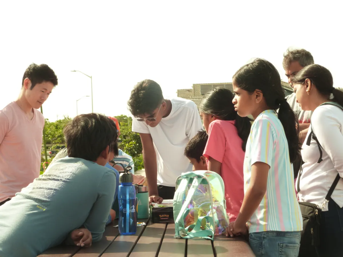 Students and instructors examining device parts together